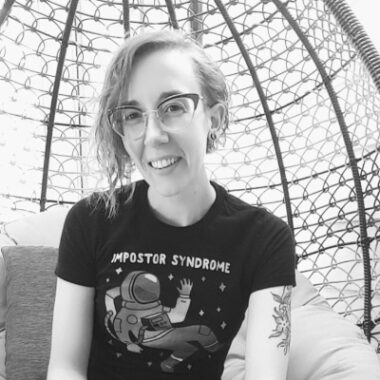 A person with glasses smiling at the camera.