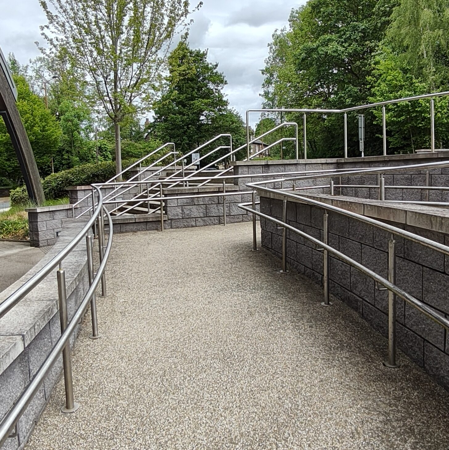 Pebble-dashed path with silver railings.