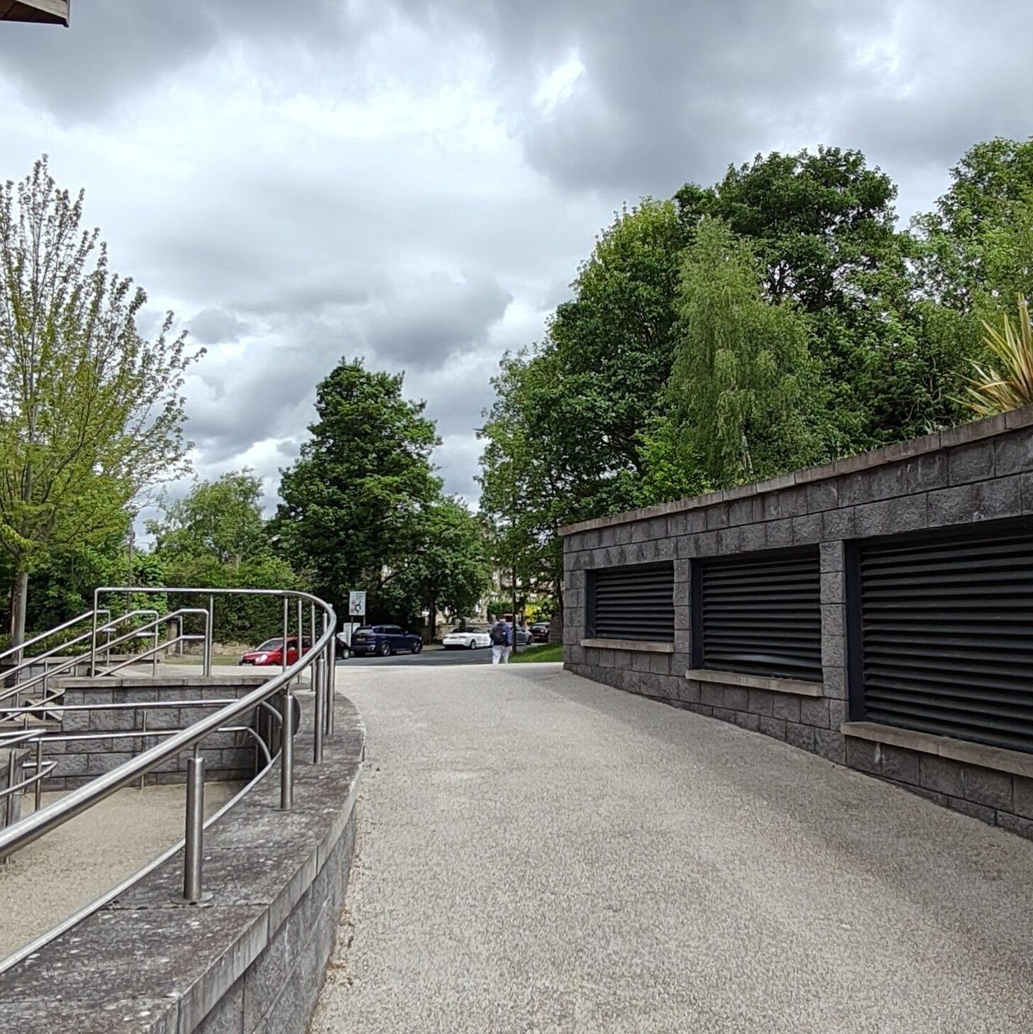 Pebble-dashed path with silver railings on the left-hand side.